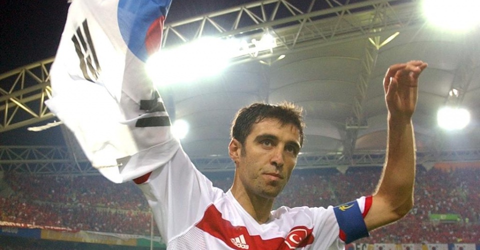 FILE - In this Saturday, June 29, 2002, file photo, Turkey's Hakan Sukur holds a South Korean flag at the end of the 2002 World Cup third place playoff soccer match between South Korea and Turkey, at the Daegu World Cup stadium, in Daegu, South Korea.  Turkey's state-run news agency reports Friday, Aug. 12, 2016, authorities have issued an arrest warrant for former soccer star and legislator Hakan Sukur over his alleged links to a U.S.-based Muslim cleric, accused by Turkey of masterminding last month's failed coup. (AP Photo/Vincent Yu, FILE)