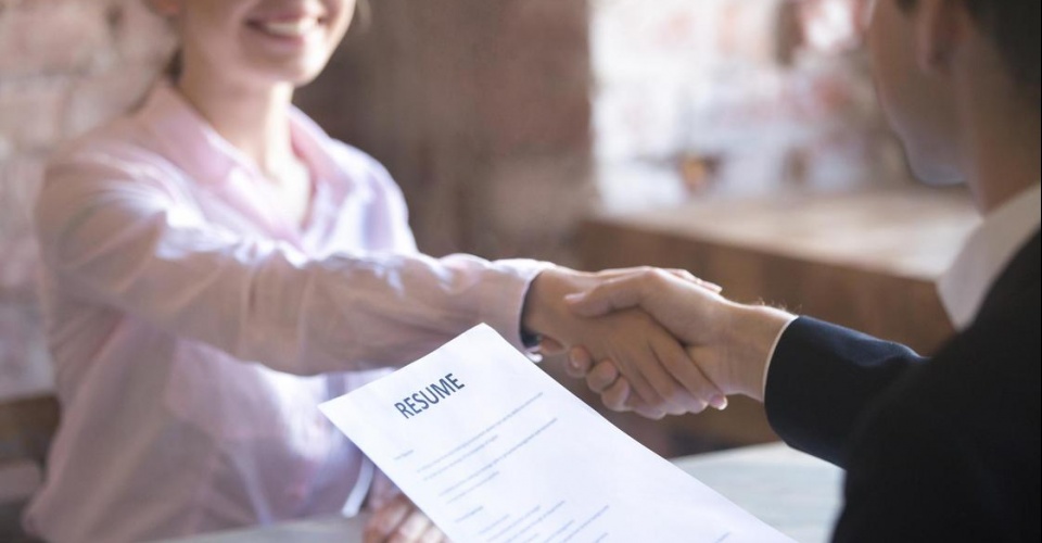 Smiling young woman and man handshake. Businesspeople shaking hands. Human resources, successfully passing the interview, hr concept. Close up resume paper