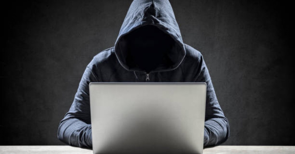 Computer hacker stealing data from a laptop concept for network security, identity theft and computer crime